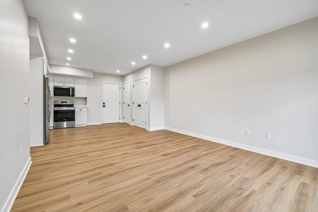 Open-plan living room with wide-plank flooring and recessed lighting